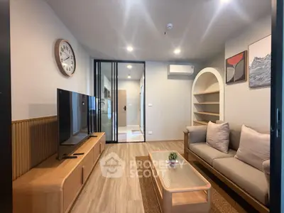 Modern living room with stylish furniture and large TV, perfect for relaxation.