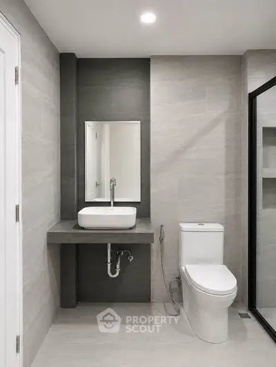 Modern bathroom with sleek design, featuring a wall-mounted sink and contemporary toilet.