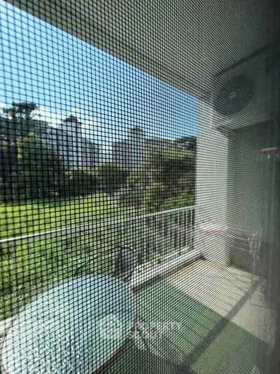 Charming balcony view with lush greenery and outdoor seating, perfect for relaxation.