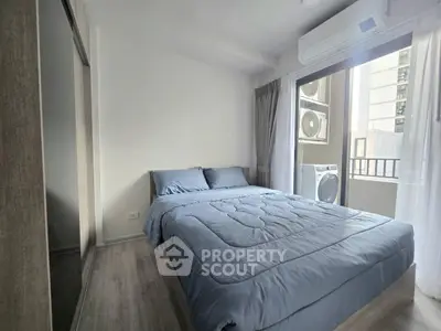 Modern bedroom with balcony access and air conditioning in urban apartment