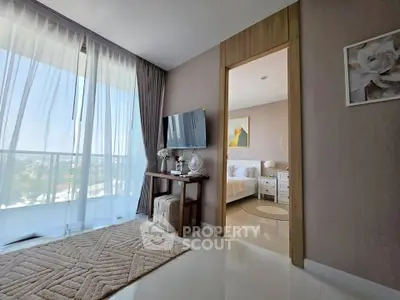 Modern apartment interior with living room and bedroom, featuring large windows and elegant decor.