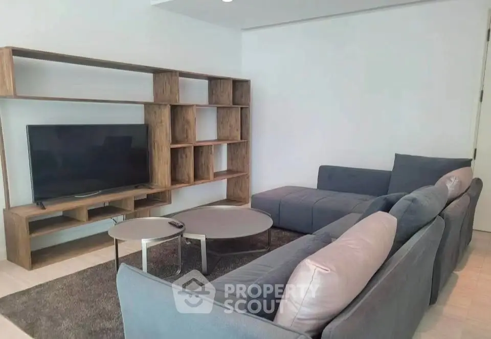 Modern living room with stylish gray sofa and wooden TV stand