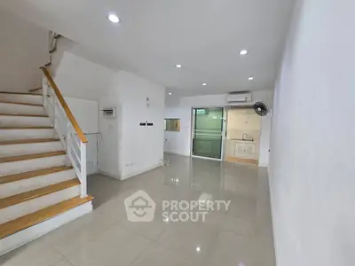 Spacious modern living room with staircase and open kitchen layout