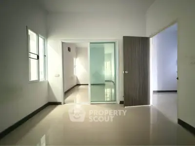 Spacious empty room with sliding glass doors and ample natural light