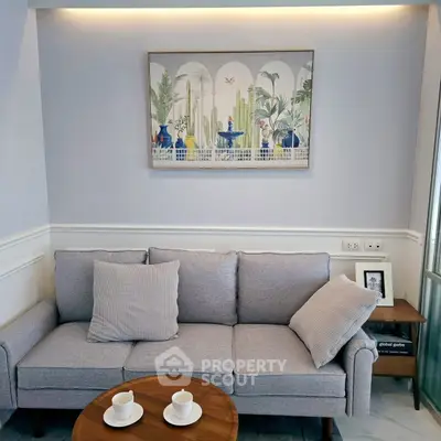 Chic living room with modern gray sofa and stylish wall art, perfect for cozy relaxation.
