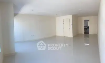 Spacious empty living room with glossy floors and neutral walls, ready for customization.