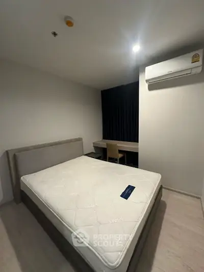 Modern bedroom with minimalist design featuring a comfortable bed and air conditioning.