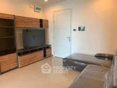 Modern living room with sleek furniture and mounted TV in a cozy apartment.