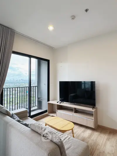 Modern living room with balcony and city view, featuring sleek furniture and a large TV.
