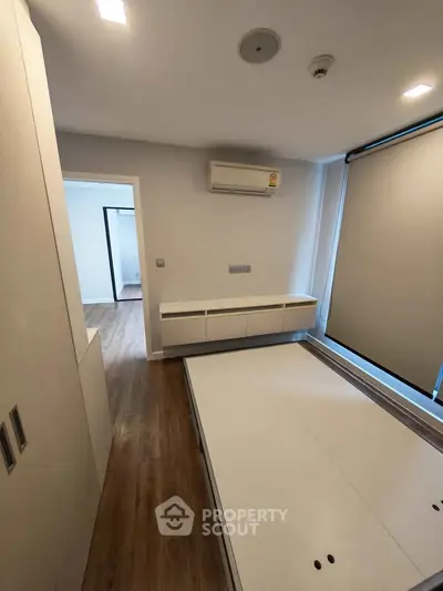 Modern bedroom with built-in storage and air conditioning in a stylish apartment.