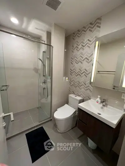 Modern bathroom with glass shower and sleek fixtures in a contemporary home.