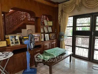 Elegant living room with wooden decor and large windows, showcasing a cozy and inviting atmosphere.