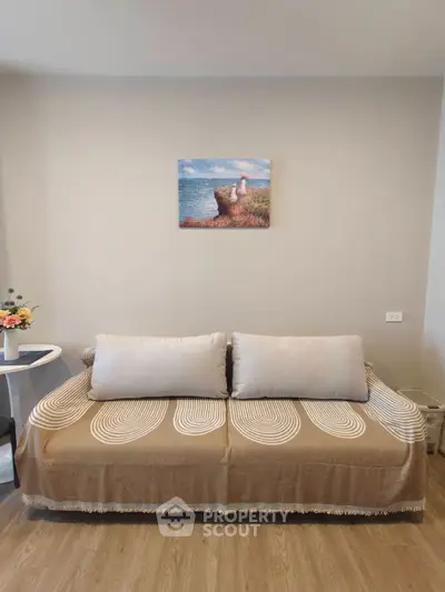 Cozy living room with stylish sofa and wall art, perfect for relaxation.