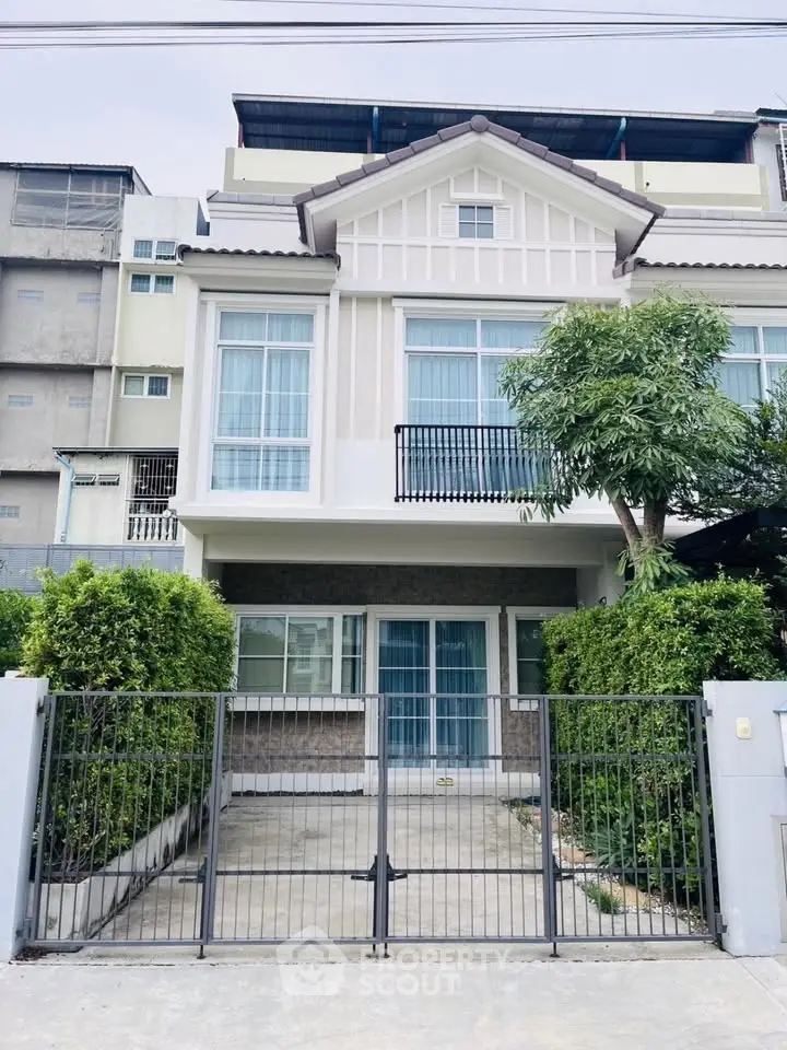 Charming two-story house with modern facade and lush greenery, perfect for family living.