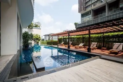 Luxurious modern apartment pool with sun loungers and pergola, perfect for relaxation and leisure.