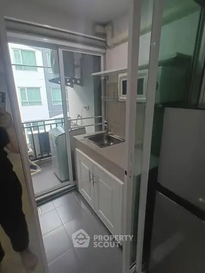 Compact kitchen with balcony view in modern apartment