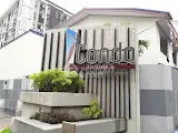 Modern condo entrance with stylish architectural design and lush greenery.