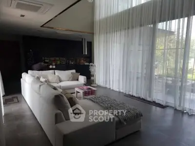 Luxurious living room with modern white sofa and floor-to-ceiling windows