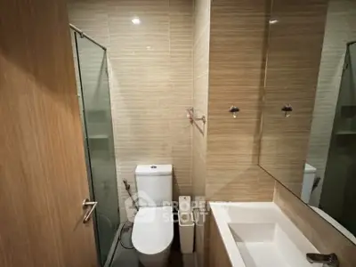 Modern bathroom with glass shower and sleek fixtures in a contemporary apartment.