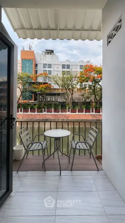 Charming balcony with seating overlooking a scenic canal view, perfect for relaxation and enjoying the outdoors.