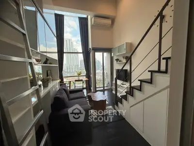 Modern loft apartment with high ceilings and city view, featuring a cozy living area and stylish staircase.