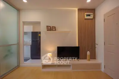 Modern living room with stylish decor and sleek TV unit in a cozy apartment.