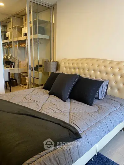 Luxurious bedroom with tufted headboard and mirrored closet doors