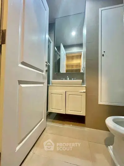 Modern bathroom with sleek vanity and large mirror in contemporary apartment.