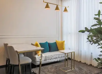 Stylish living room with modern decor, featuring a cozy sofa, elegant lighting, and a lush plant by the window.