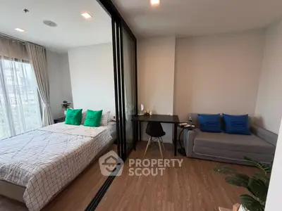 Modern studio apartment with glass partition, cozy bed, and stylish workspace.