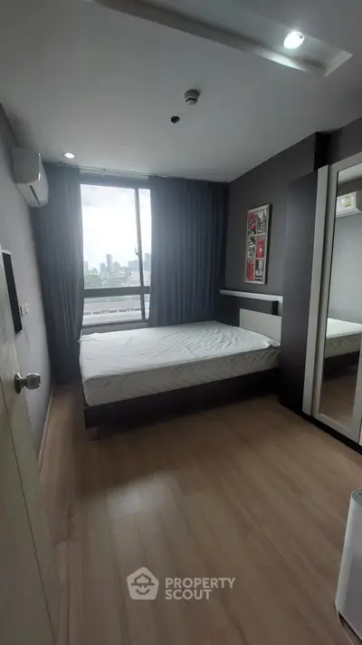 Modern bedroom with city view, featuring sleek design and ample natural light.