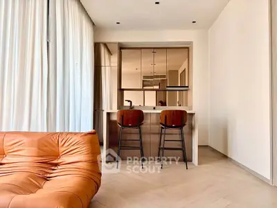 Modern living room with stylish leather sofa and sleek kitchen bar area, perfect for urban living.
