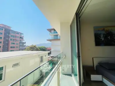 Modern apartment balcony with glass railing and city view