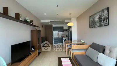 Modern living room with open kitchen, stylish decor, and cozy seating area in a contemporary apartment.