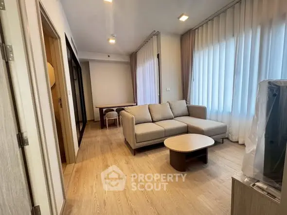 Modern living room with cozy sofa and natural light, perfect for relaxation and entertaining.