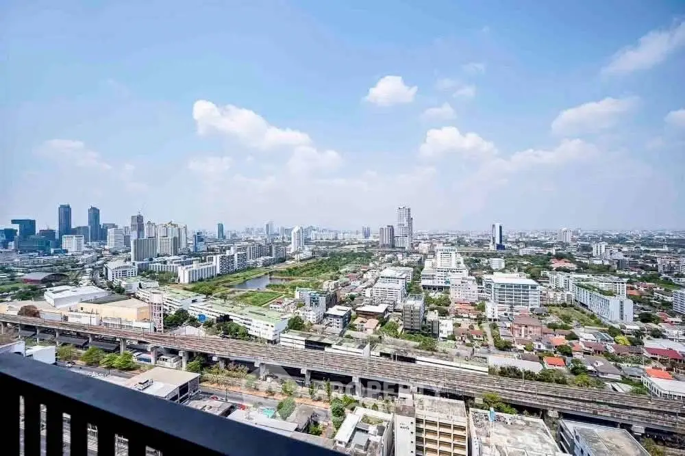 Stunning cityscape view from high-rise balcony showcasing urban skyline and railway.