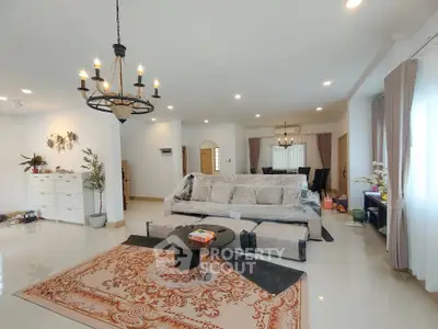 Spacious living room with elegant chandelier and large windows in modern home