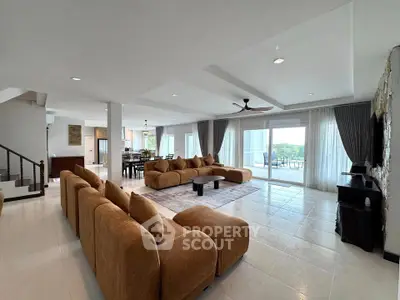 Spacious modern living room with large windows and elegant furnishings, perfect for relaxation and entertainment.