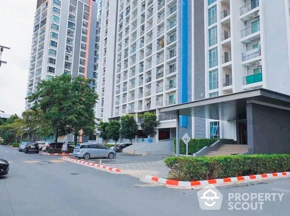 Modern high-rise condominium building with street view and parking area