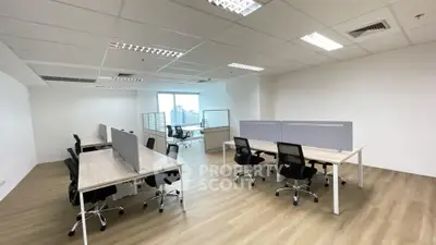 Spacious modern office space with open layout and city view, ideal for collaborative work environment.