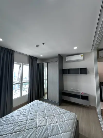 Modern bedroom with large windows and city view, featuring sleek furniture and air conditioning.