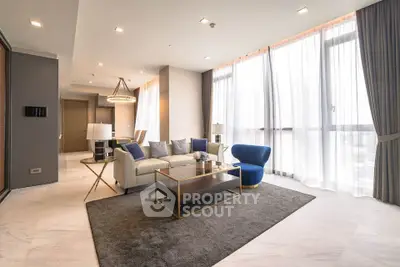 Luxurious modern living room with elegant furniture and large windows offering abundant natural light.