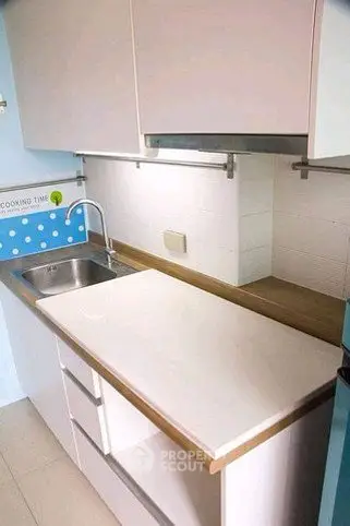 Modern kitchen with sleek cabinetry and stainless steel sink, perfect for culinary enthusiasts.