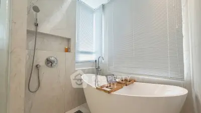 Luxurious bathroom with freestanding tub and modern fixtures in elegant marble setting.