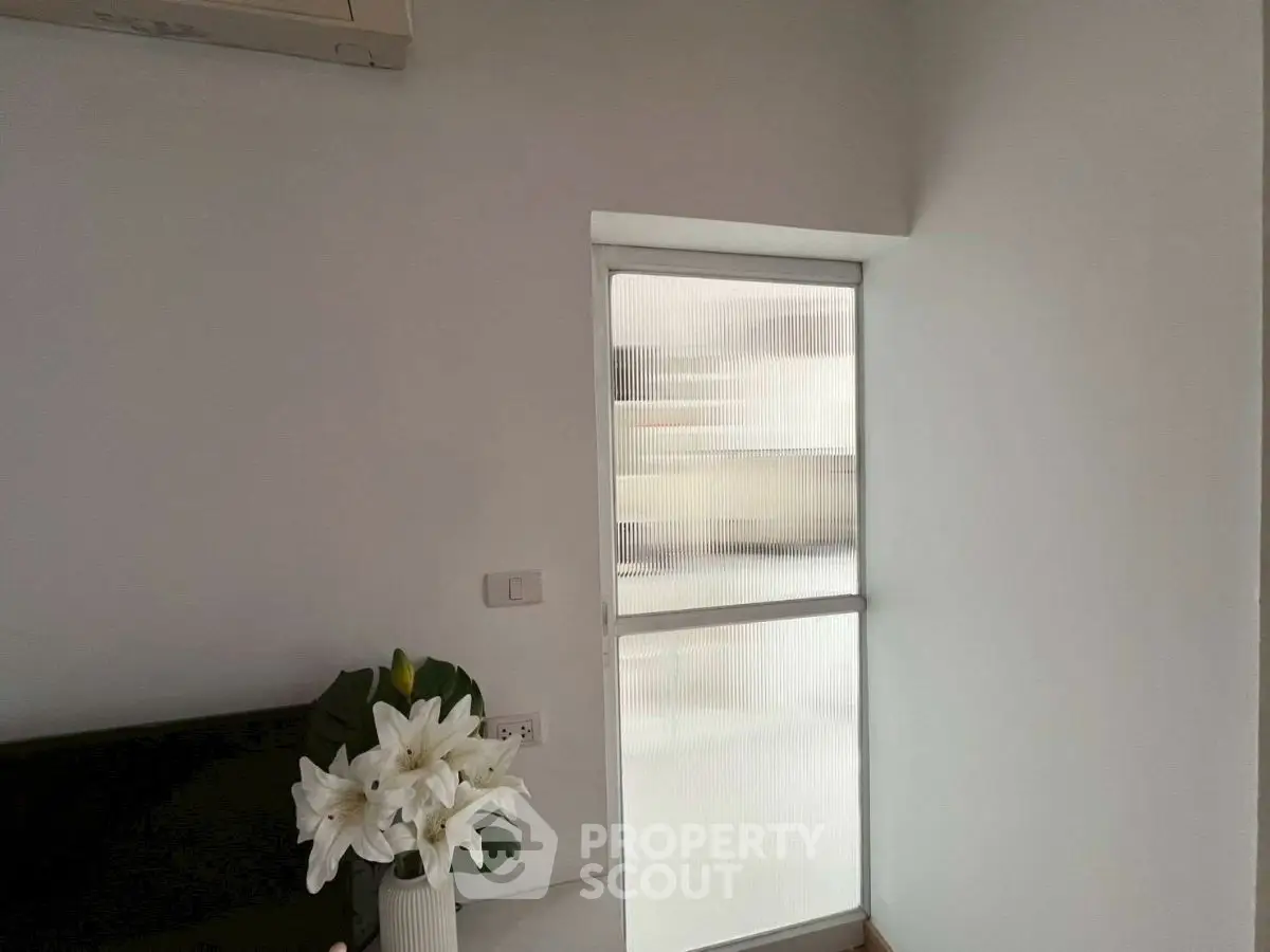 Minimalist interior with frosted glass window and elegant floral decor