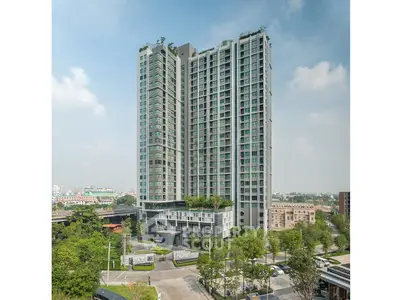 Modern high-rise building with lush greenery and cityscape view, perfect for urban living.