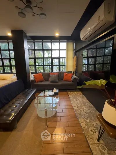 Stylish living room with modern decor, large windows, and cozy seating area.