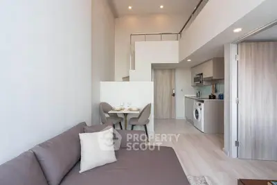 Modern apartment interior with open layout and washing machine in kitchen area.