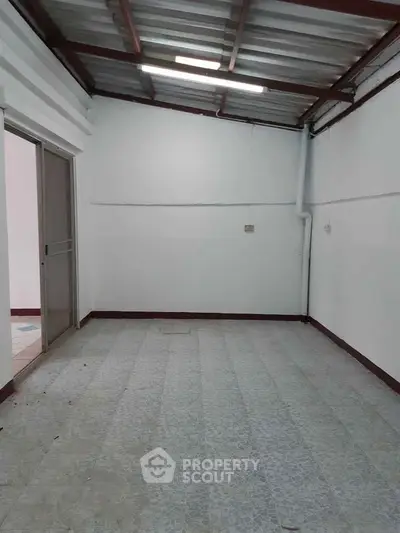 Spacious empty room with tiled floor and sliding door, ideal for customization.