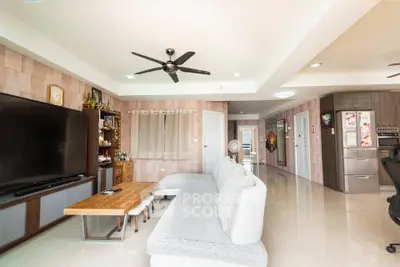 Spacious modern living room with sleek furniture and large TV, perfect for family gatherings.